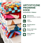 Stos kolorowych pikowanych koców – eleganckich i trwałych.
